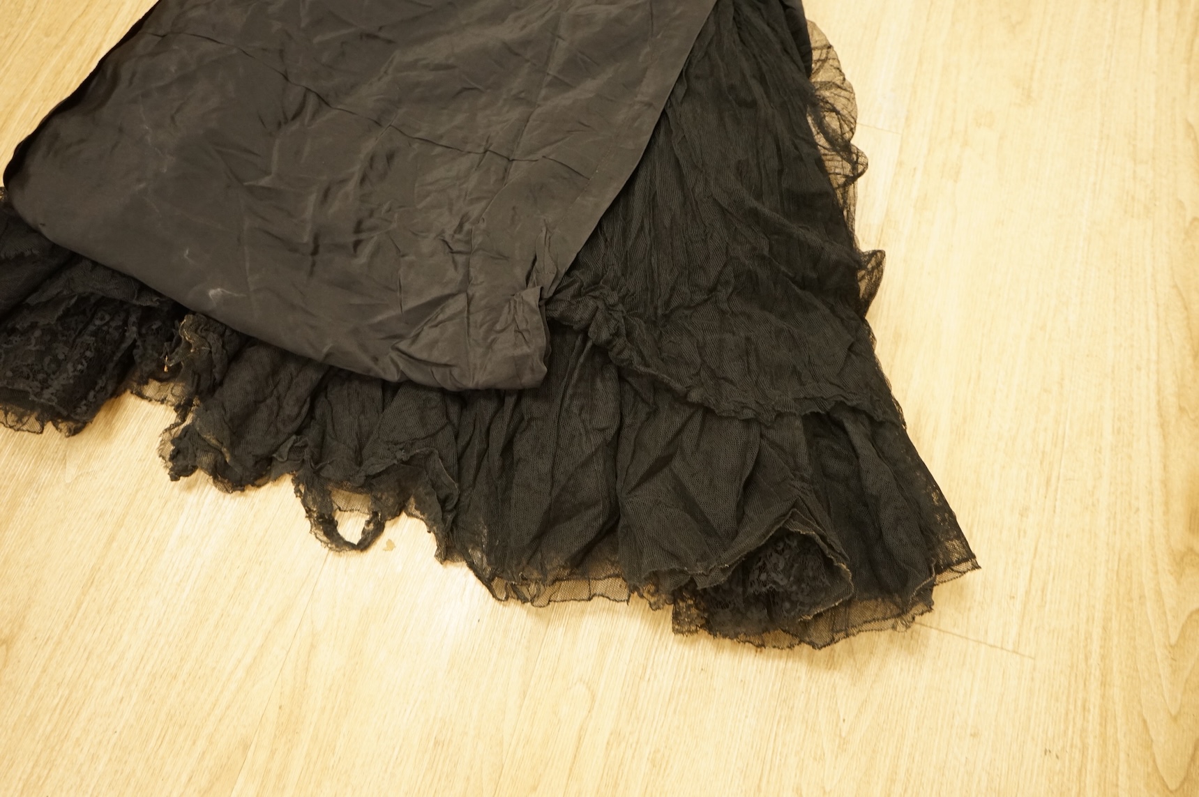 A late 1940’s black lace evening dress, a similar evening dress with black velvet ribbon detail, a maroon brocade halter neck evening dress and a dark mustard early 1950’s evening silk duster coat.